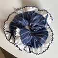 Vue détaillée d'un chouchou à rayures bleues avec volants en dentelle et nœuds marine - Style Bleu Rayé Bord Dentelle