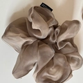 Detail van champagnekleurige organza scrunchie met modelabel en afgewerkte rand - Khaki Gestreept