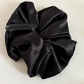 Macro shot of large black satin scrunchie with smooth texture and soft glossy finish - Black