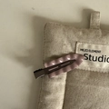 Detalle de la pinza de pelo de metal violeta con textura ondeada sobre fondo de tela - Clip Ondulado sin Costuras / Color Té con Leche
