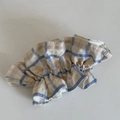 Detailopname van een geruite haarelastiek met blauwe en oranje patronen op stof - Blauw Gestreepte Haarband