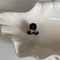 Vue détaillée d'une mini pince à cheveux noire ornée d'un petit nœud violet sur une assiette - Violet (5#)