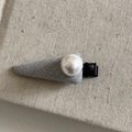 Detail of grey fabric hair clip with a centered white pearl and black metal clip - Grey Triangle Large Pearl Hair Clip