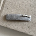 Detail view of gray textured fabric hair clip with three elegant white pearls and a stone - Grey Rectangular Hair Clip with Three Pearls