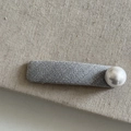 Close-up of a gray textured fabric hair clip with a large white pearl accent - Grey Rectangular Large Pearl Clip