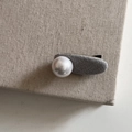 Dettaglio dell'ovale in tessuto grigio e della grande perla bianca sulla clip per capelli - Fermaglio Ovale Grigio con Perla Singola