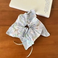 Scrunchie floreale con motivi a coniglio blu e fiocco in nastro su tavolo di legno - Elastico Fiocco Aquilone Texture Blu
