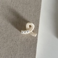 Détail d'une pince à cheveux en résine blanc crème avec trois perles sur tissu texturé - Petite pince croisée / Blanc