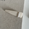 Dettaglio molletta per capelli crema con quattro perle bianche su sfondo di lino - Stile Triangolo / Bianco