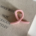 Close-up of matte pink claw clip with golden metal spring on vintage book background - 5# Pink Ribbon Knot