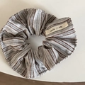 Detail eines gestreiften Haargummis mit einem cremefarbenen smile life Stoffetikett - Blau Kaffee Gestreifter Stil