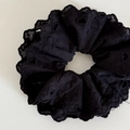 Dettaglio di elastico in pizzo nero con ricamo traforato e bordi con volant eleganti - Elastico Pizzo Cuore Nero