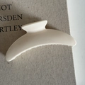 Close-up of a minimalist cream-white curved hair claw clip on a book for daily styling - 15# Cream White Arc