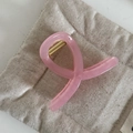 Dettaglio di un fermaglio per capelli in resina rosa traslucida con molla in metallo - Stile a Croce Piccola Rosa