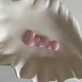 Dettaglio del fermaglio per capelli rosa ondulato con finitura opaca su piatto a conchiglia - Rosa
