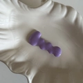 Fermaglio per capelli a onde in metallo viola su piatto bianco con texture a conchiglia - Viola