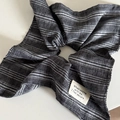 Détail d'un chouchou rayé noir et blanc avec texture textile et étiquette tissée - Chouchou Rayé Noir Blanc