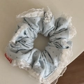 Detalle de un coletero azul claro con estrellas, encaje blanco y etiqueta de marca - Estilo de Malla de Encaje / Azul Claro Estrella