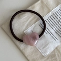 Vue détaillée d'un pendentif cœur en résine rose sur un élastique à cheveux marron - Corde à Cheveux Cœur Rose