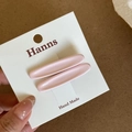 Detail view of two minimalist light pink handmade hair clips on a white display card - Pink Oval Hair Clip