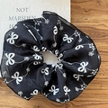 Nahaufnahme von schwarzem Mesh-Haargummi mit weißen Schmetterling- und Schneeflocken-Stickereien - Schleifen-Scrunchie / Schwarz