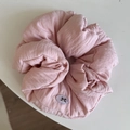 Close-up of light pink oversized scrunchie featuring textured fabric and a bow tag detail - 14cm / Pink