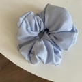 Detail of light blue scrunchie with soft fabric folds and a decorative white button - 14cm / Blue