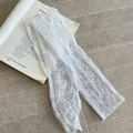 Dettaglio del nastro in pizzo bianco con ricamo floreale su sfondo di libro antico - Rete a Linee Floreali Bianche (2#)