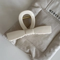 Detailaufnahme einer cremefarbenen Schleifen-Haarklammer mit goldener Metallfeder - Beige lange Schleife Haarklammer
