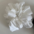 Detailed view of oversized white satin scrunchie with a glossy silk-like texture - White