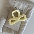 Dettaglio di un fermaglio per capelli a fiocco color crema in acrilico su tessuto - Pinza per capelli a doppio triangolo giallo