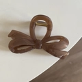 Detail of translucent brown bow hair claw clip showing the strong gold metal spring - Transparent Champagne
