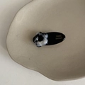 Detail of a handmade floral hair clip with black and white marble pattern on a ceramic tray - Black and White Flower Accessory Clip