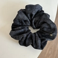 Detalle de un coletero de terciopelo negro con etiqueta LOVE y colgante dorado elegante - Azul marino