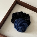 Close-up of a velvet rose hair tie in deep blue and black on a brown display tray - Flocked Blue Flower (1#)
