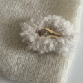 Gros plan sur une pince à cheveux en peluche grise sur tricot blanc pour style hivernal - Blanc Cassé