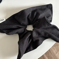 Detailed macro view of dark navy fabric scrunchie with fine twill texture and logo label - Black Kite Style
