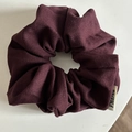 Close-up of wine red scrunchie fabric texture and FMares brand tag detail - Brick Red