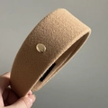 Detailed macro shot of khaki wool headband texture with gold metal emblem accent - Milk Tea With Gold Label