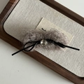 Détail d'une pince à cheveux en peluche marron avec nœud noir et perle de cristal - Barette Peluche Kaki