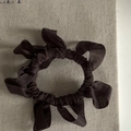 Macro detail of coffee brown pleated chiffon hair scrunchie with layered wave texture - Khaki