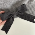Detailed close-up of a large grey knitted bow on soft ribbed fabric hair accessory - Dark Gray