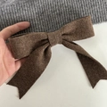 Chic knit hair clip featuring a dark brown bow on grey ribbed fabric for autumn winter style - Coffee