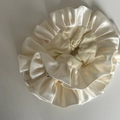 Detalle de un coletero de satén crema con elegante textura plisada y acabado brillante - Blanco Roto