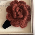 Nahaufnahme der burgunderroten Strickblumen-Haarklammer mit schwarzer Samtbasis im Retro-Stil - Weinrot Wollblume Haarspange