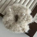 Dettaglio dell'elastico in peluche beige crema con perle su un vassoio per gioielli - 1# Elastico Perle Lana di Agnello Beige