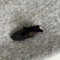 Détail d'une pince à cheveux à nœud en ruban noir avec plaque argentée sur tricot gris - Pince Goutte Noire Avec Nœud