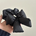 Dettaglio di un elastico per capelli con fiocco nero imbottito e tessuto lucido 3D - Scrunchie con Fiocco Nero