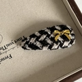 Close-up of houndstooth tweed hair clip featuring a delicate gold metal bow accent - White Black Stripe Drop Hair Clip Gold Bow