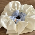 Vista dettagliata dell'elastico in pizzo crema con strisce blu ed etichetta Hand Made - Scrunchie Grande Bordo Bianco Righe Blu